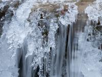 Spitz zulaufende Eisfigur an Bachkaskade